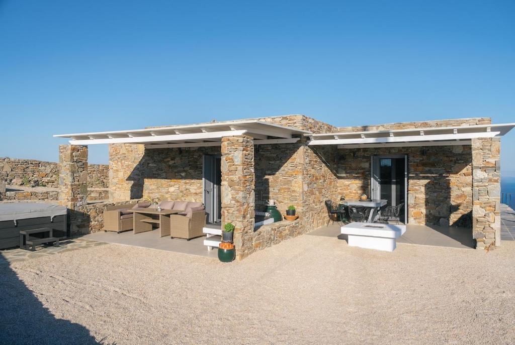 a stone house with a patio with a grill at Vigla View Sifnos in Vathi