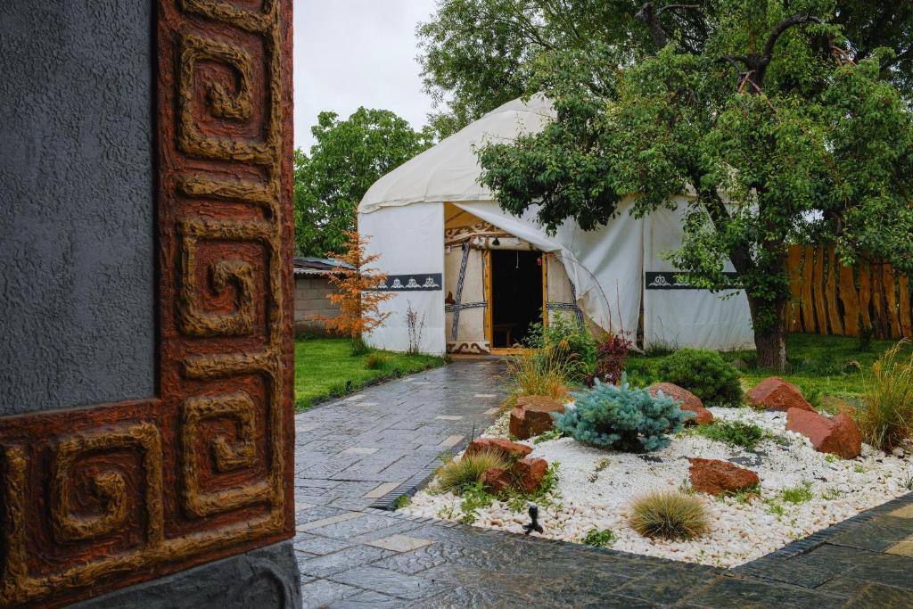 a tent with a garden in front of it at Kurjun Guest House in Bokonbayevo