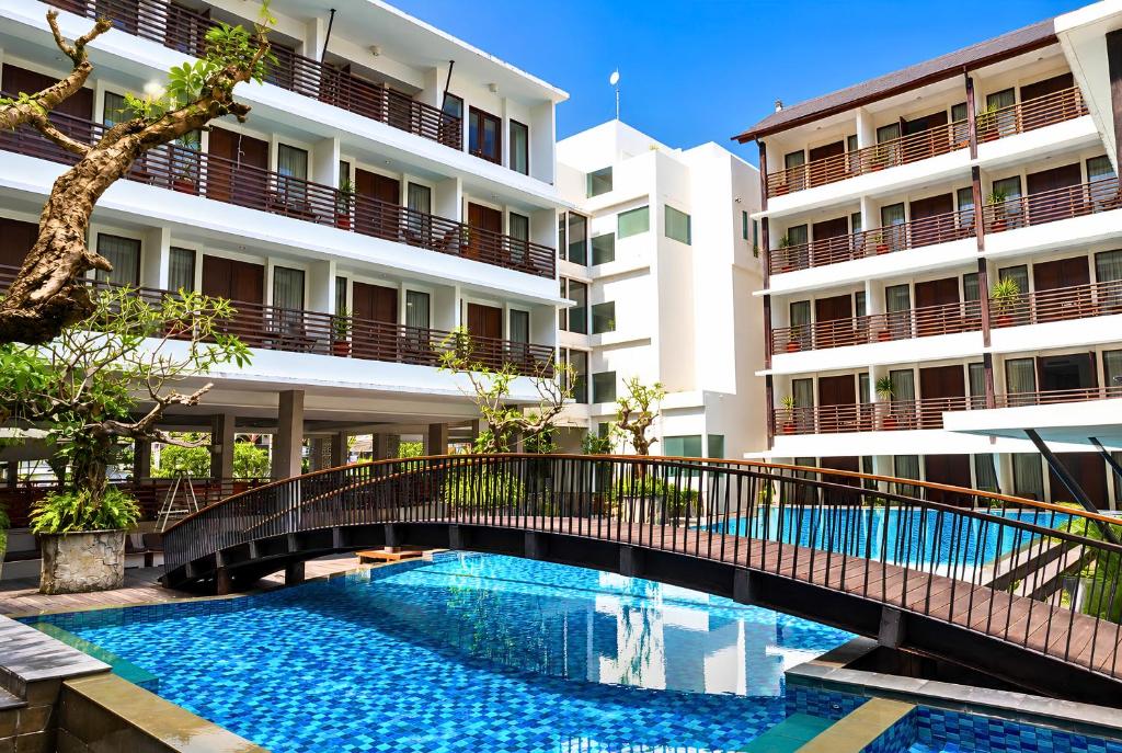 a bridge over a swimming pool in front of a building at Sun Island Hotel & Spa Kuta in Kuta