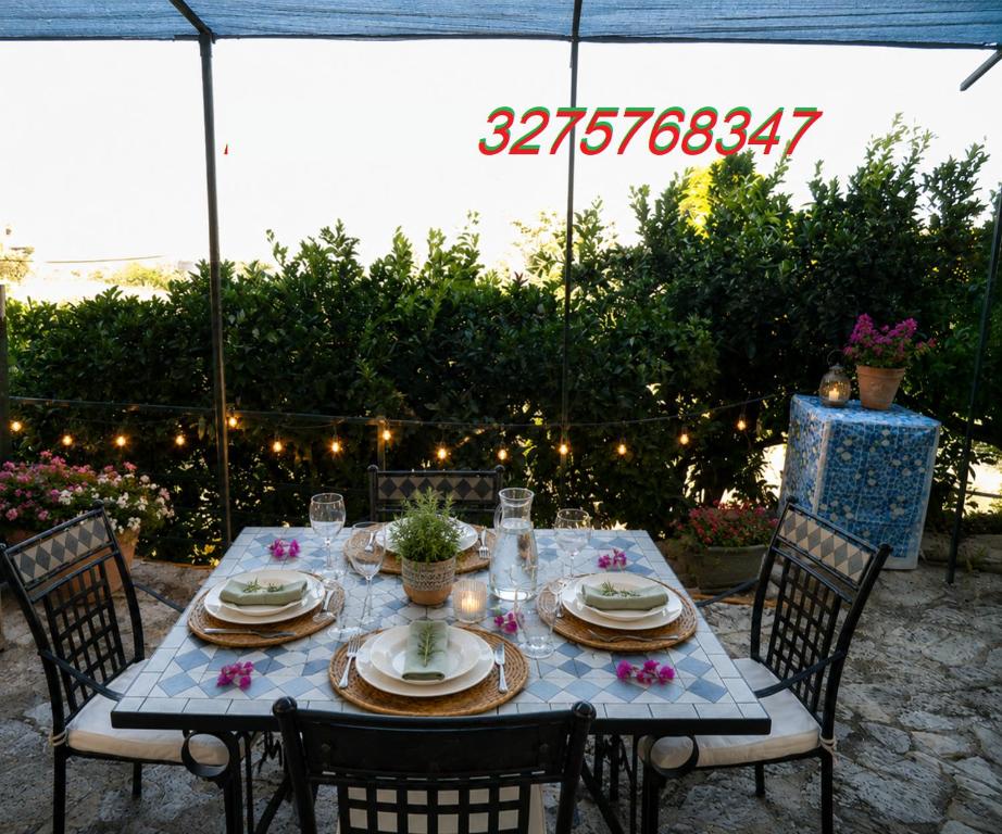 a table with chairs and plates and candles on it at Valle Verde 4 Clima & Wi-Fi in Castellammare del Golfo