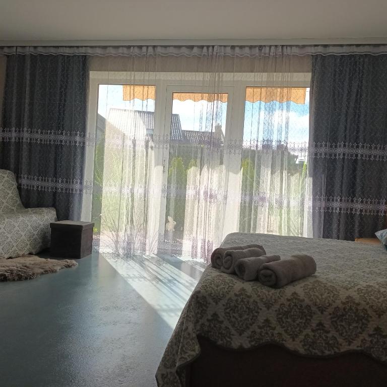 a bedroom with a bed with rolled towels on it at Idille Studio with Patio & Free Parking in Ventspils
