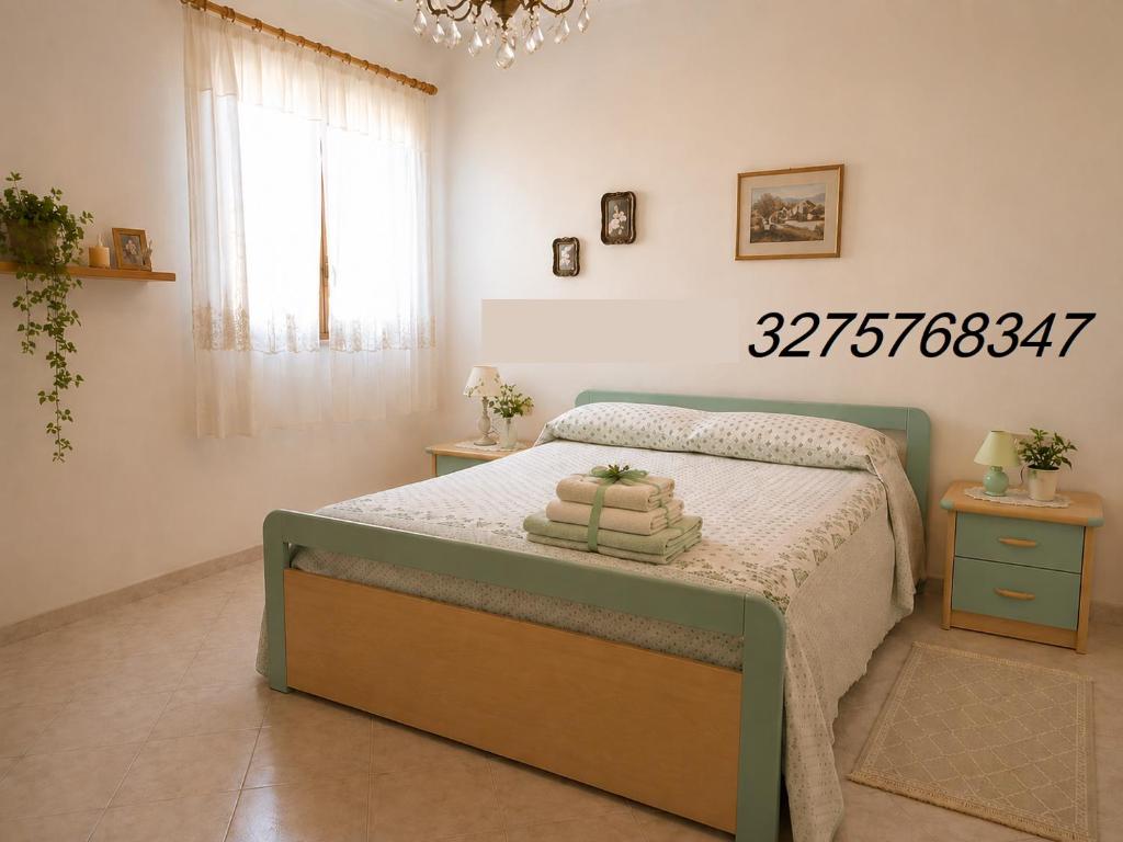 a bedroom with a bed and a chandelier at Valle Verde 3 Clima & Wi-Fi in Castellammare del Golfo