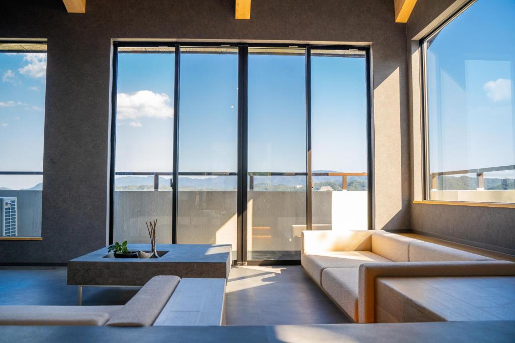 a living room with a couch and large windows at Villa LUAR in Minamiawaji