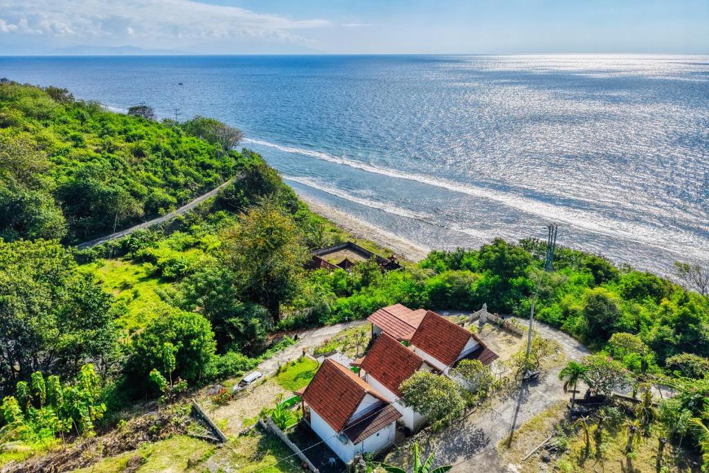 an aerial view of a house on a hill next to the ocean at Kapouk Cottage in Nusa Penida