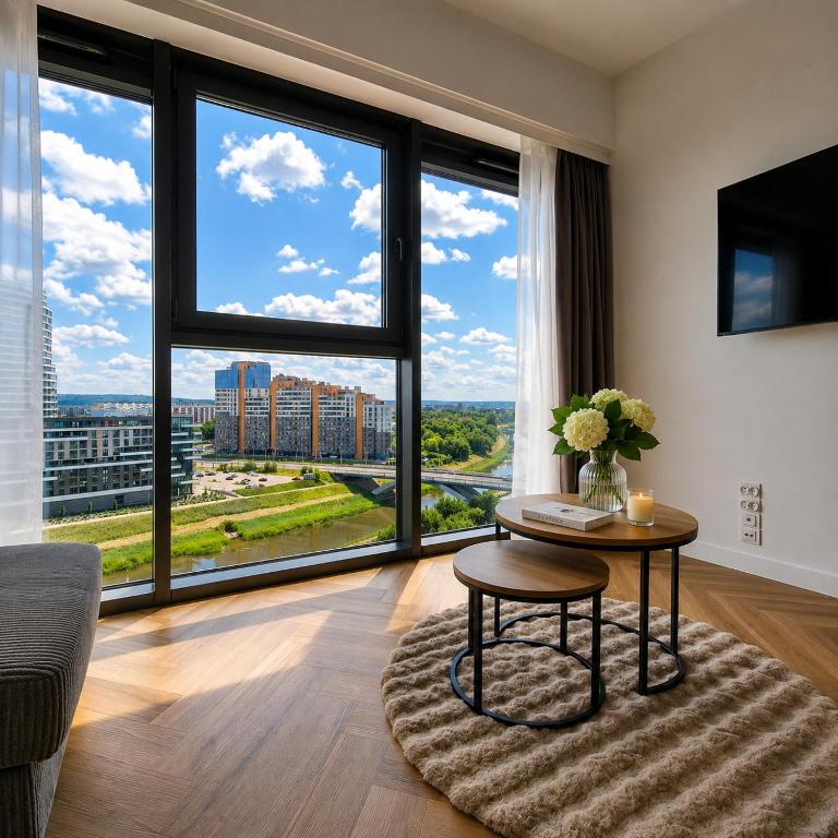 a living room with a table and a large window at Olszynki Park Elite Residence in Rzeszów