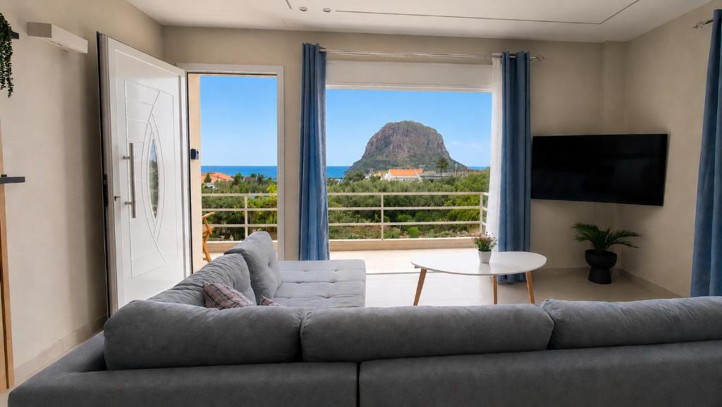 a living room with a couch and a large window at Limera View Monemvasia in Monemvasia