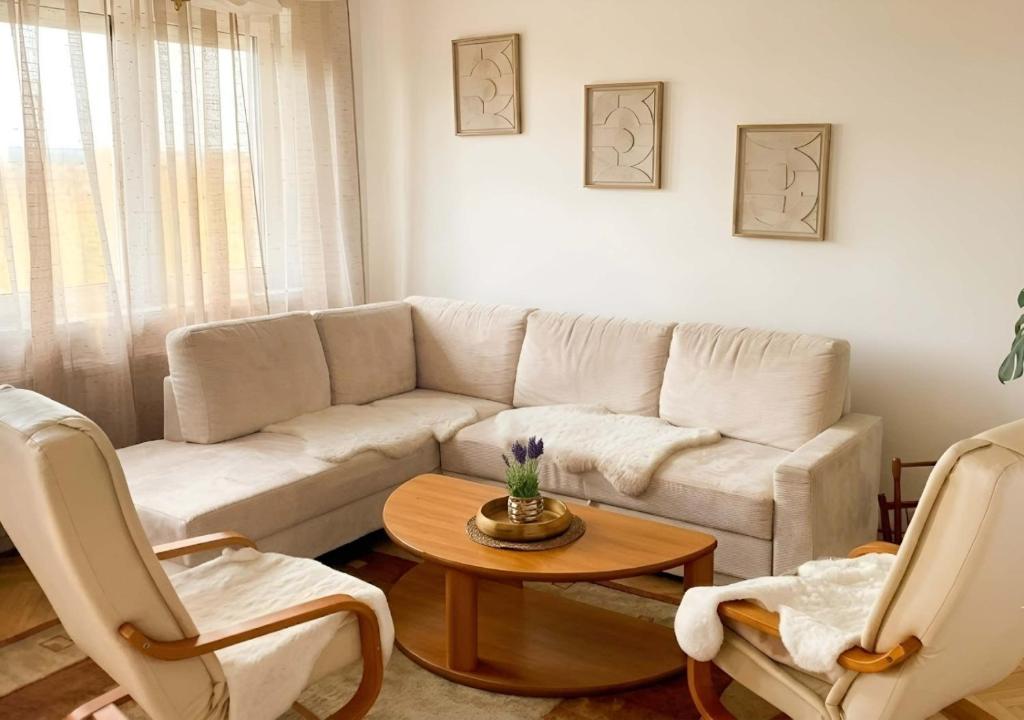 a living room with a white couch and two chairs at Villasobota in Rimavská Sobota