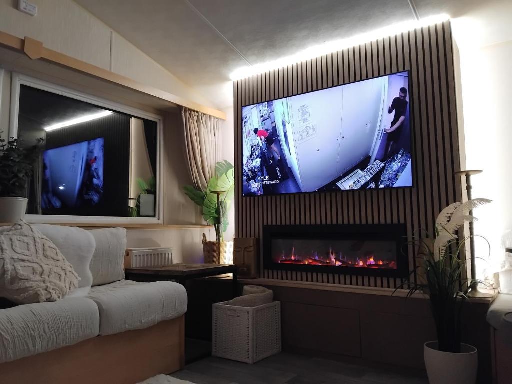 a living room with a tv and a fireplace at Magnolia in Porthcawl