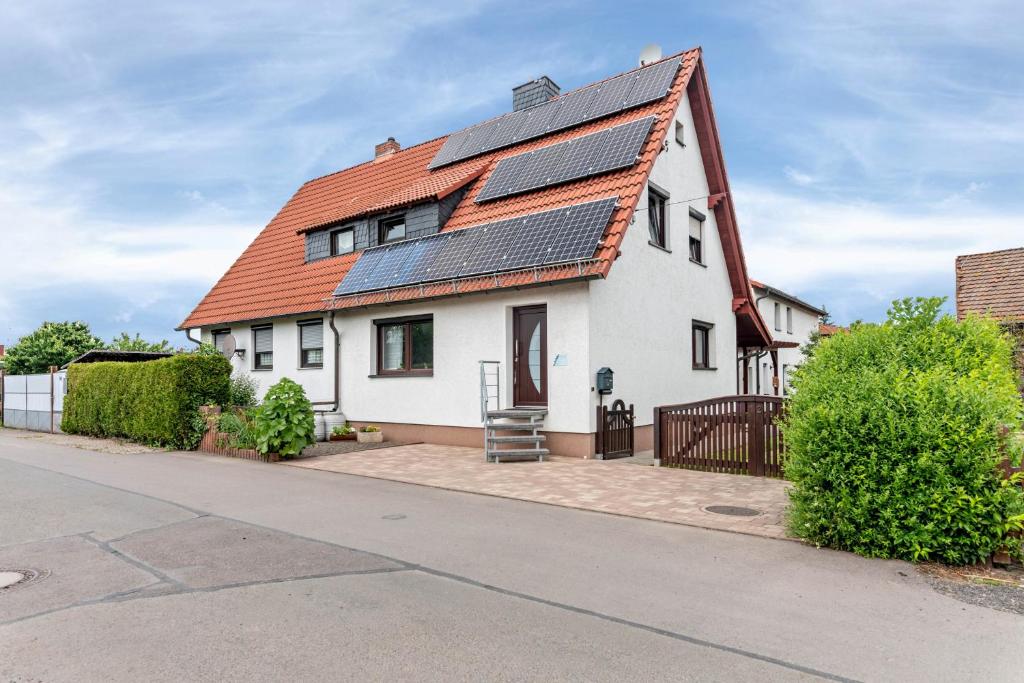 a white house with solar panels on the roof at Fewo Drei Gleichen Nr 2 in Wandersleben