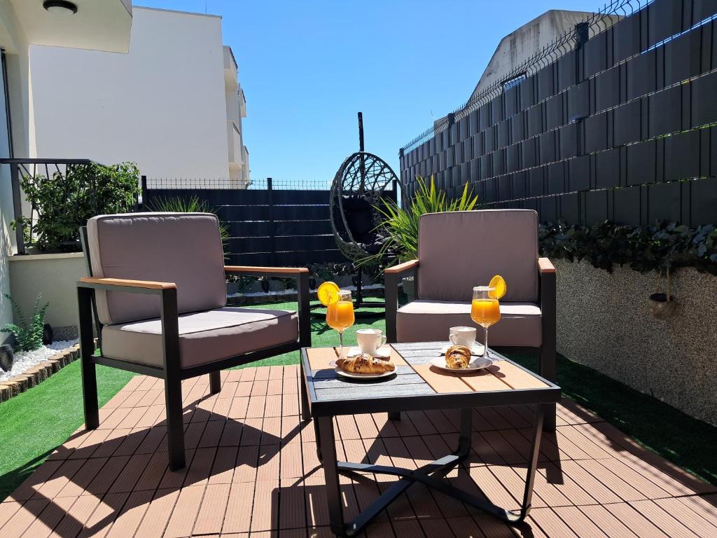 two chairs and a table with drinks on a patio at Luxury Mint Garden Apartment in Kaštela