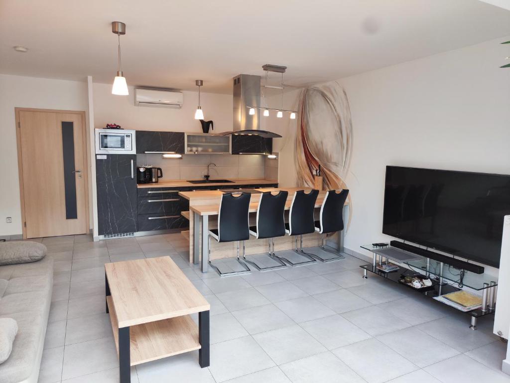 a living room with a table and a kitchen at Apartmány Duo in Dačice