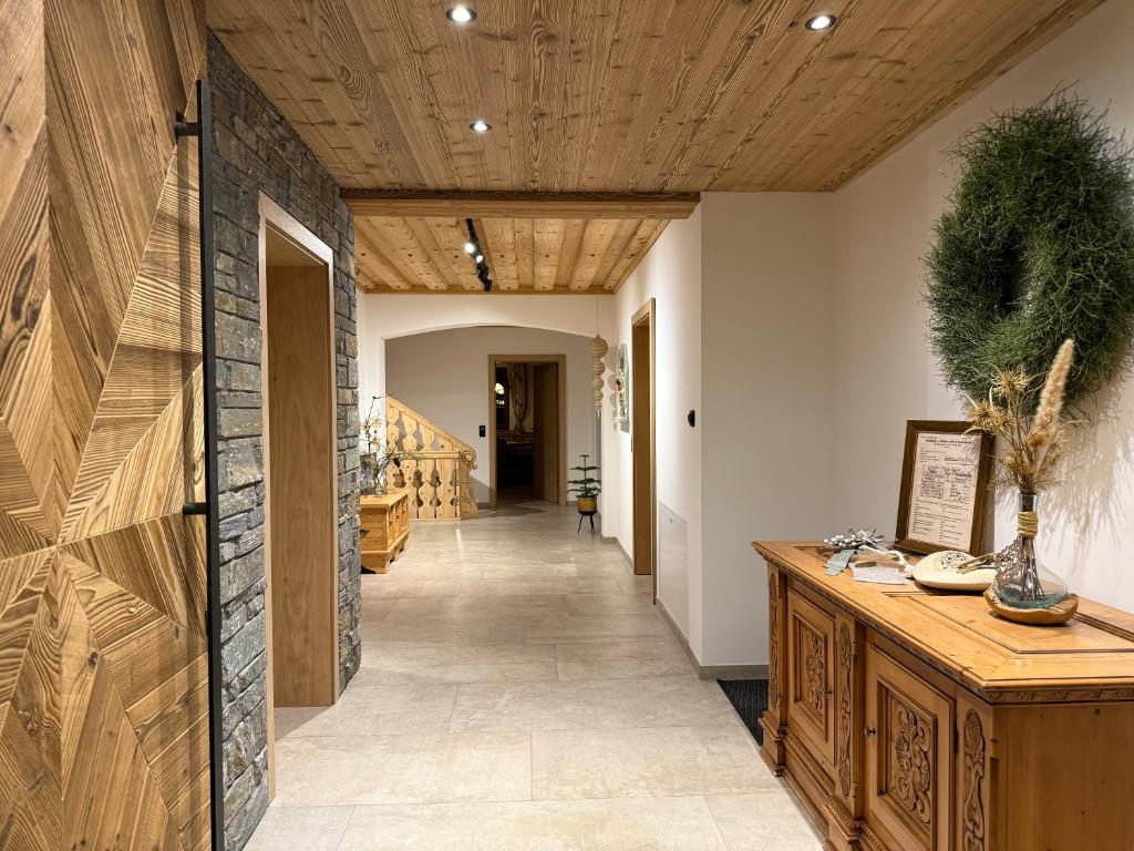 a hallway with a wooden ceiling and a hallway with stairs at Untergrundgut in Leogang