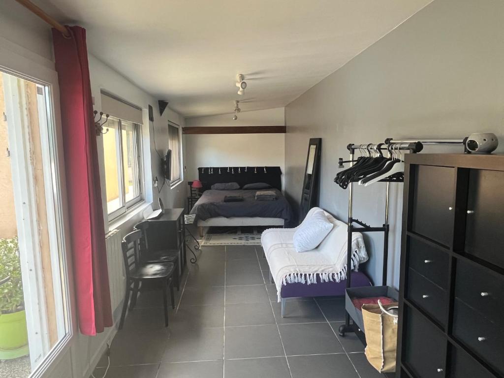 a room with a bed and a table and chairs at Dépendance de Maison in Saint-Genis-Laval