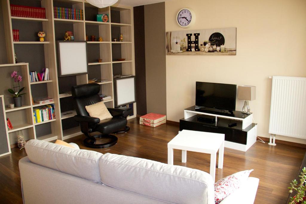 un salon avec un canapé blanc et une télévision dans l'établissement Home-sweet-home, à Haguenau