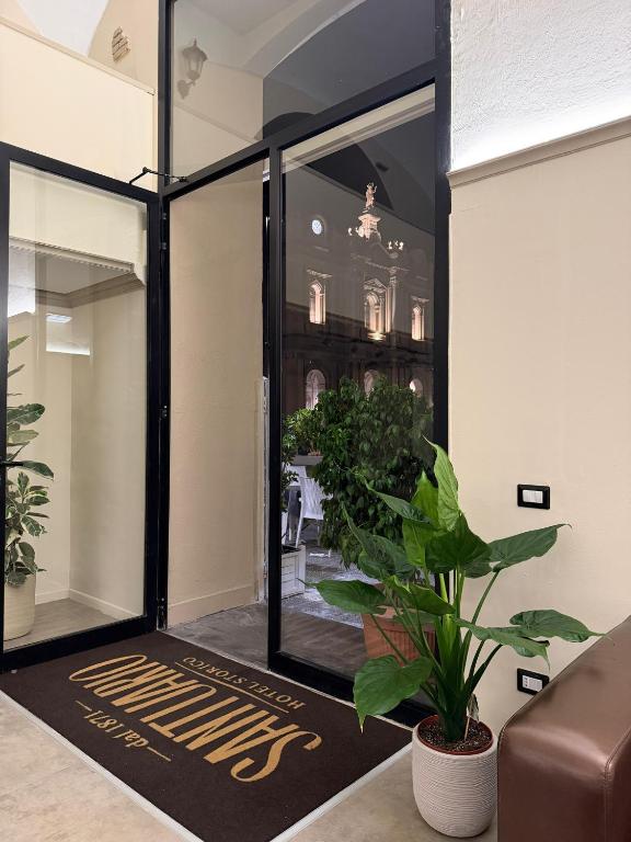 a glass door with a plant in a room at Hotel Santuario Pompei in Pompei