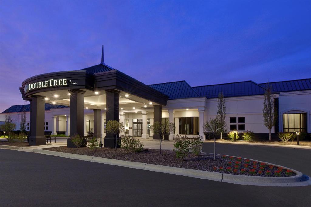 a hotel with a sign on the front of a building at DoubleTree by Hilton Hotel Detroit Novi in Novi