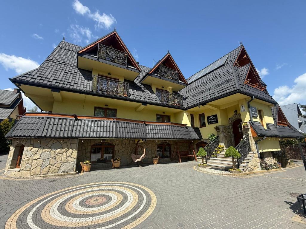 a large yellow building with a gambrel roof at Willa u Zwijaczy in Zakopane