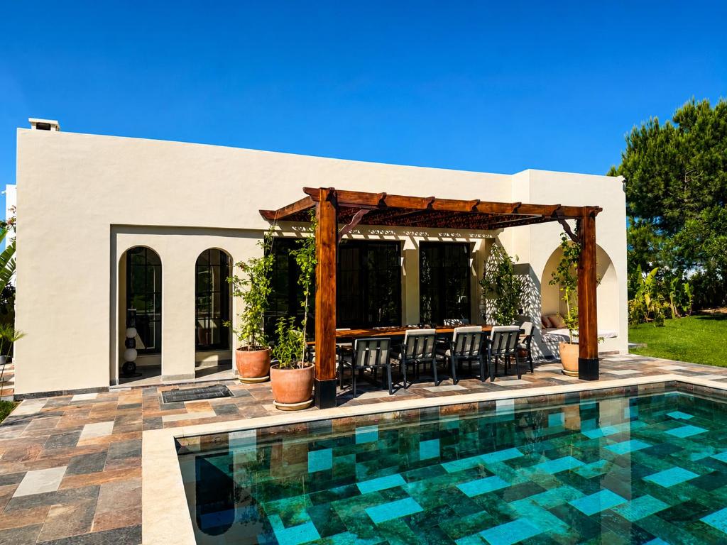 a swimming pool in front of a house at Maisonnette Olea Hammamet in Hammamet