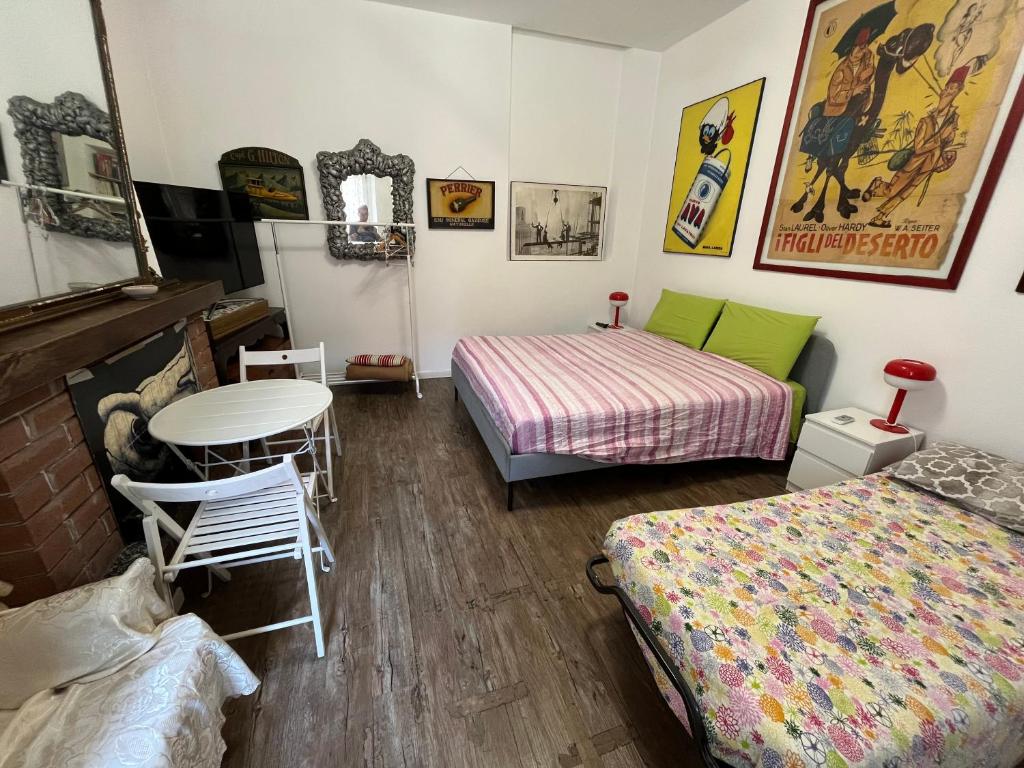 a room with two beds and a table at Room Saronno + B&B in Saronno