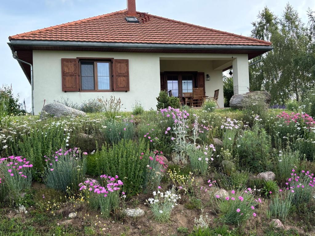 a garden in front of a house with flowers at Ostoja nad jeziorem Żywki in Żywki
