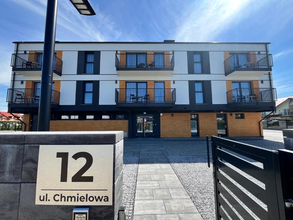 a building with a sign in front of it at Diament Apartamenty in Rowy