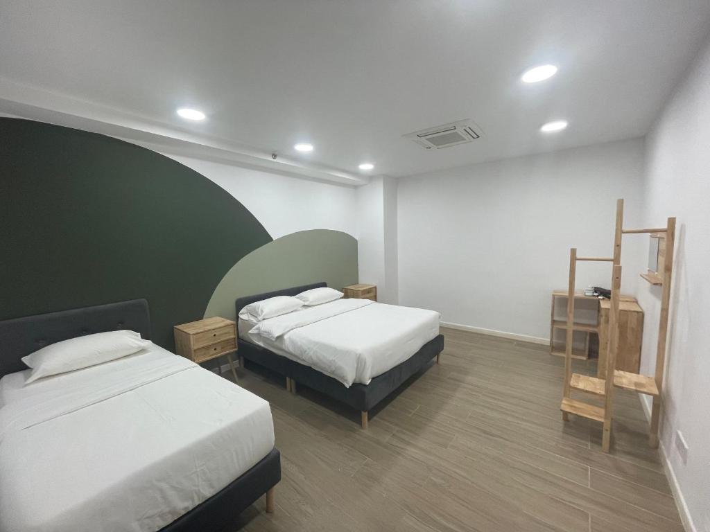 a bedroom with two beds and a green and white wall at Liwan, Baysuite by Ayuhouz in Kota Kinabalu
