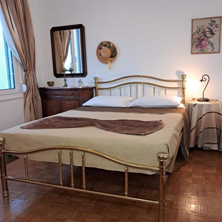 a bedroom with a large bed with a mirror and a table at Chios Studios Kalamari in Vrontádos