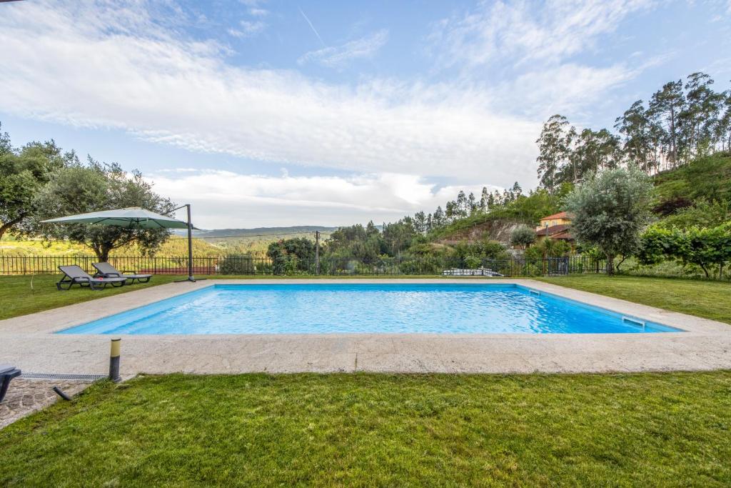 a swimming pool in the yard of a house at Casa De Pedra D'alborinhas in Arões