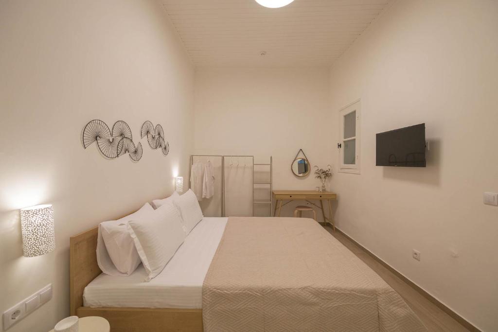 ein weißes Schlafzimmer mit Bett und Fernseher in der Unterkunft Corali 2 - Coastal Retreat in Katakolo