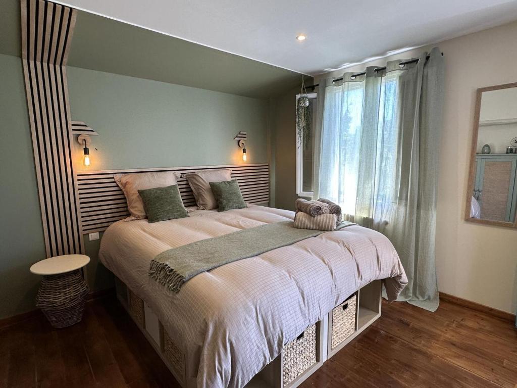 a bedroom with a large bed and a window at Maison le baron in Bélus