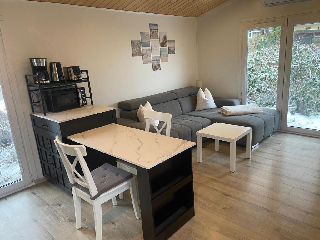 a living room with a couch and a table and chairs at Tiny House Milena in Greifswald