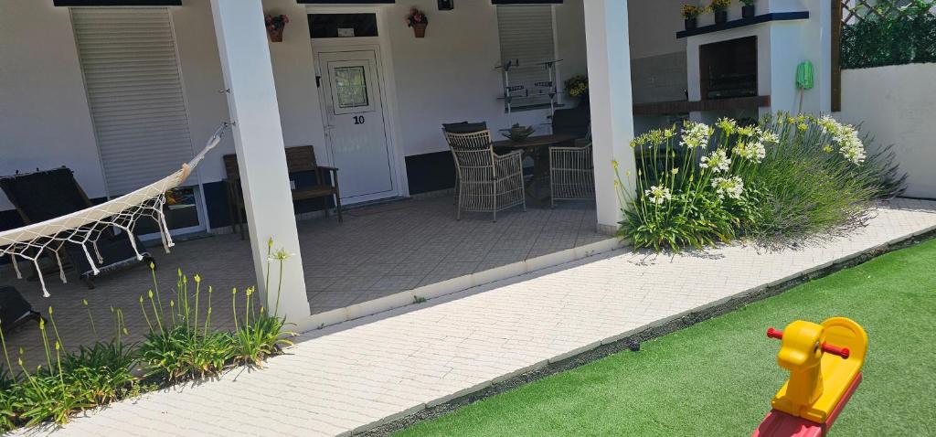 a house with a patio with a table and chairs at Casa do Chafariz - Guest House in Cercal