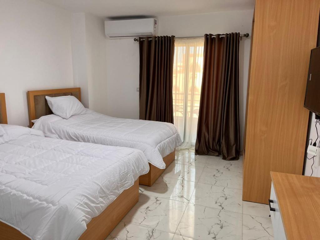 a hotel room with two beds and a window at Lavanda Beach Resort Studio - Panoramic Sea & Pool View in Abū Rudays