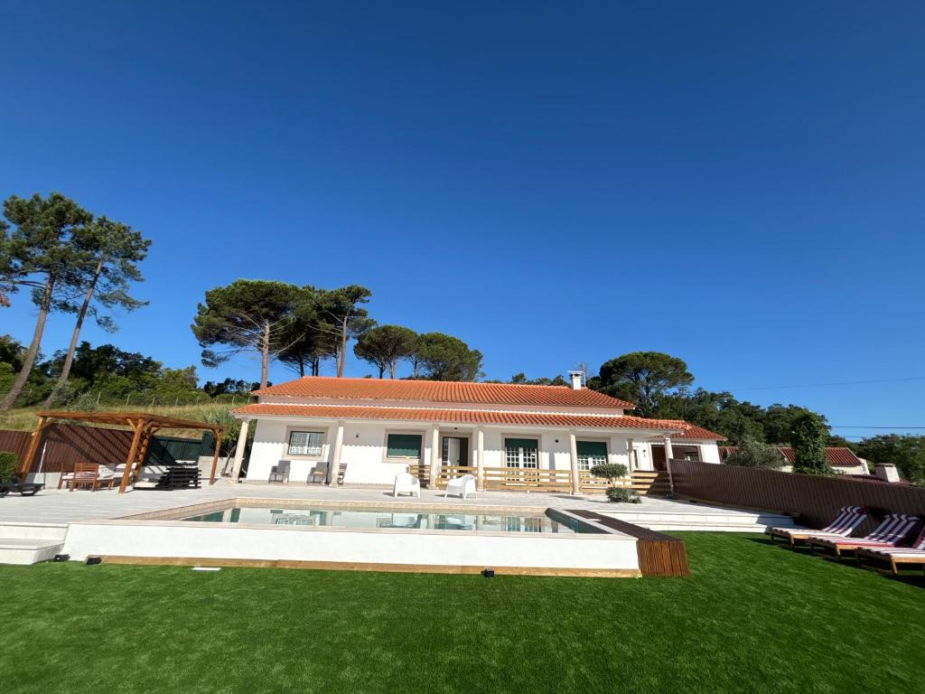 a house with a swimming pool and a yard at Casa Casal da Eva in Alcobaça