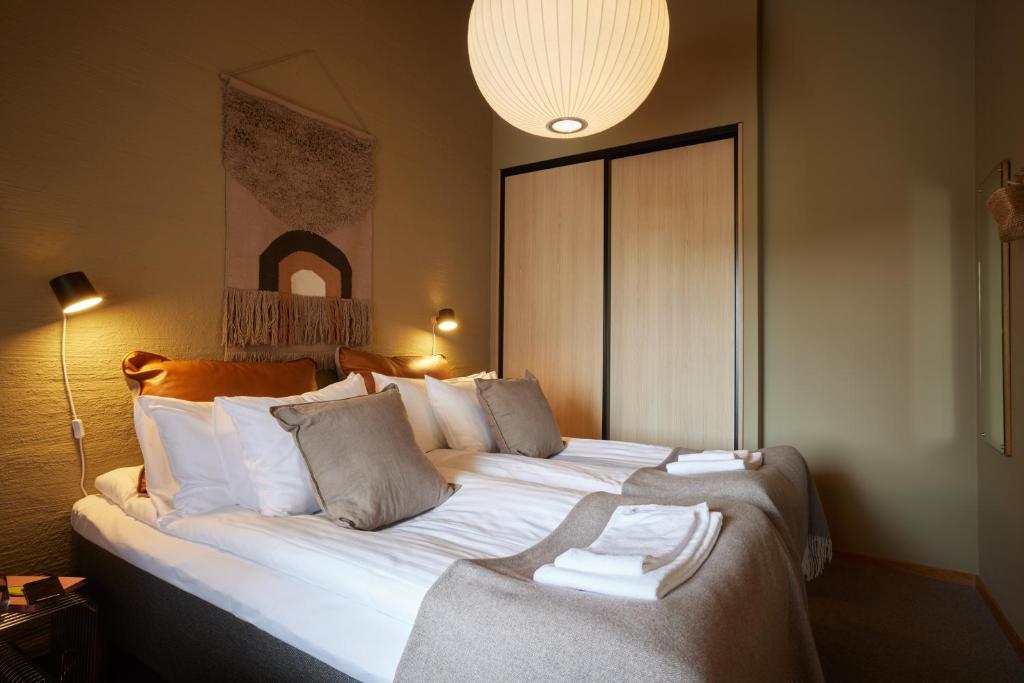 a bedroom with a large bed with white sheets at Barsebäck Resort Hotell in Löddeköpinge
