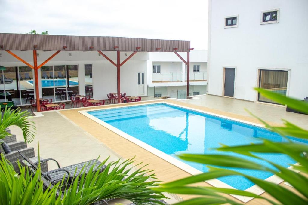 a swimming pool in front of a building at Hotel Santos Silva in São Tomé
