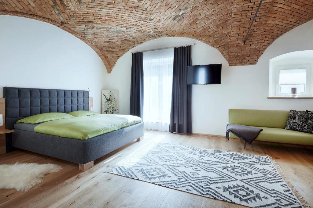 a bedroom with a bed and a couch at Brucknergut in Linz