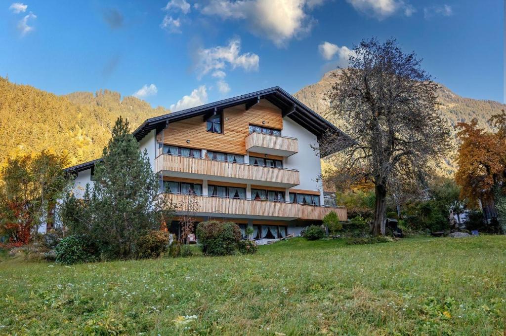 a house in a field with mountains in the background at Haus Gant in Sankt Gallenkirch