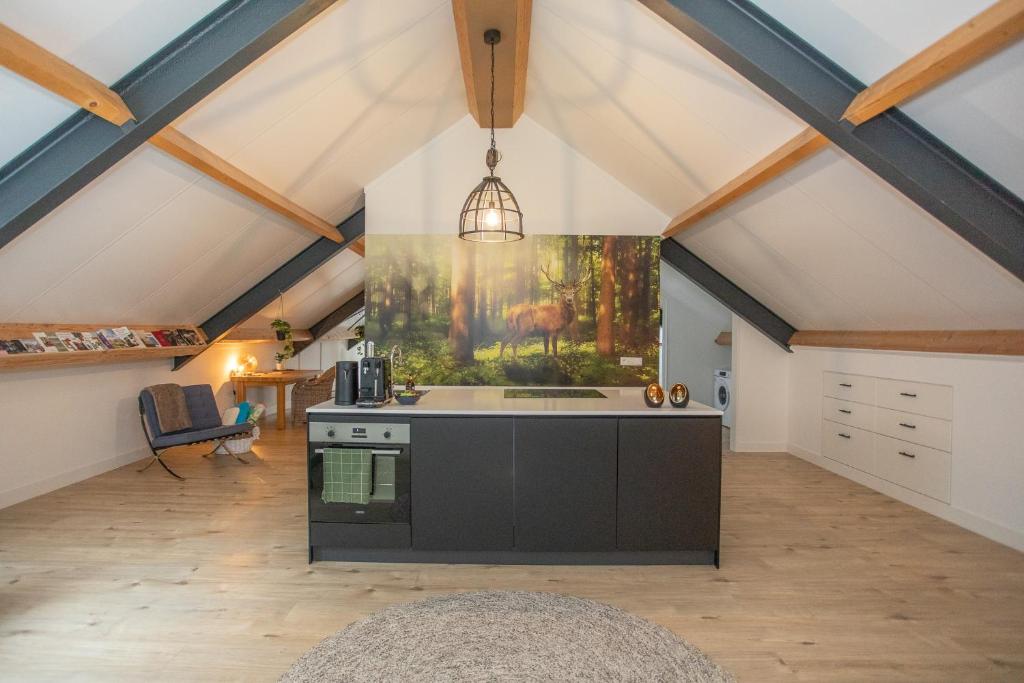 an attic kitchen with a large painting on the wall at Boerderij appartement De Casterie in Bornerbroek