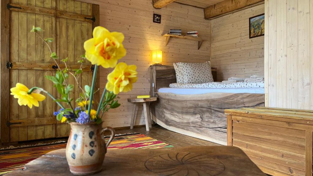 a room with a bed and a vase with yellow flowers at Breb 220D in Breb
