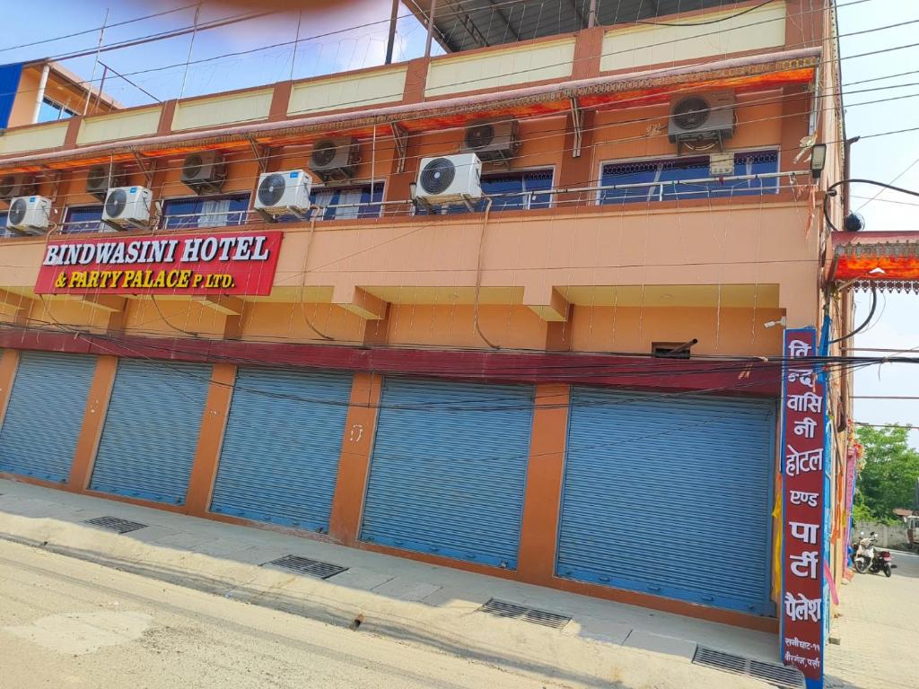 a building with blue garage doors on a street at Bindwasini Hotel And Party Palace in Bīrganj