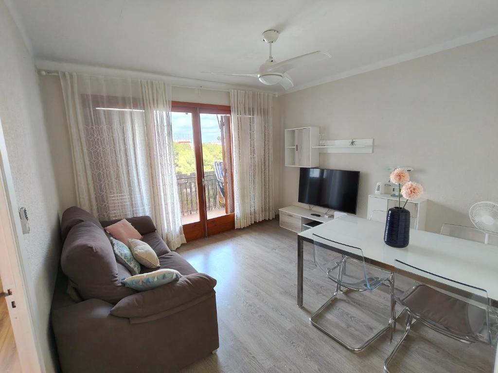 a living room with a couch and a table at Apartaments Lamoga - Sandi in Torredembarra