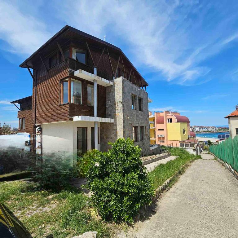 a house with a wooden roof on top of it at Transilvaniya Apartments in Sozopol