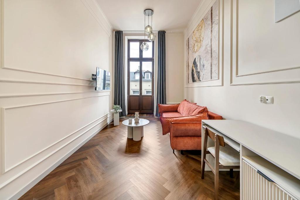 a living room with a couch and a table at Lumiere 28 Aparthotel in Łódź