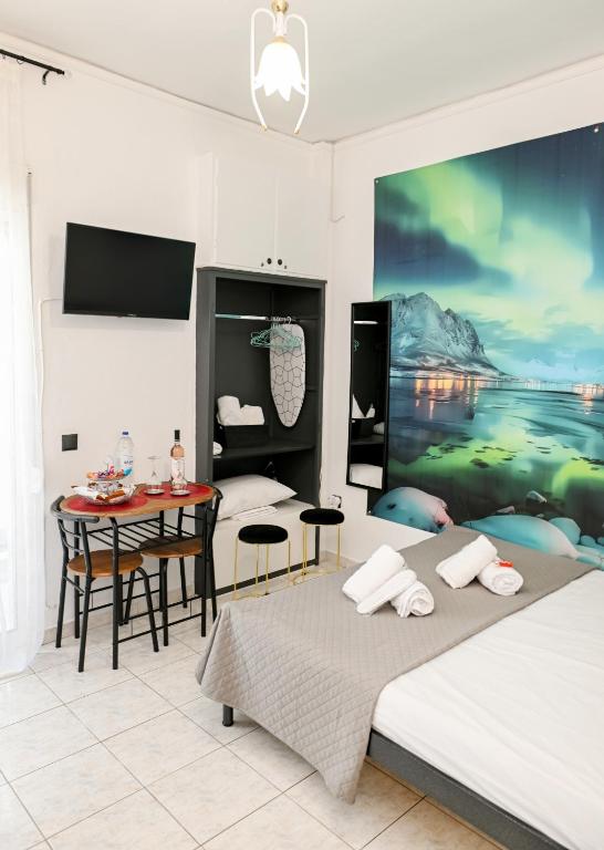 a bedroom with two beds and a table and a painting at Le Bel Appartement D'Antigoni in Alexandroupoli