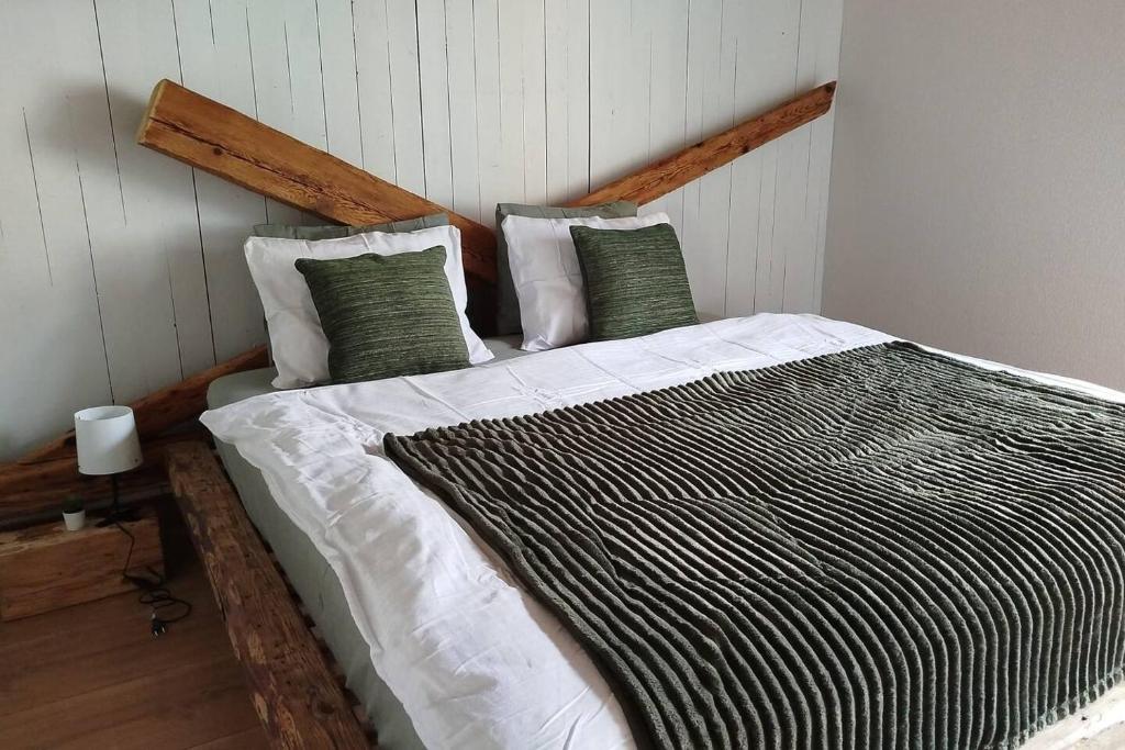 a bedroom with a large bed with green and white pillows at 20 Min nach Interlaken in Frutigen