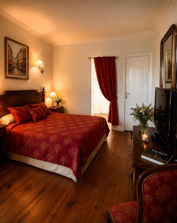 a bedroom with a bed and a television and a window at Chez Vanessa Entrée privée avec escalier in Saint-Gervais-dʼAuvergne