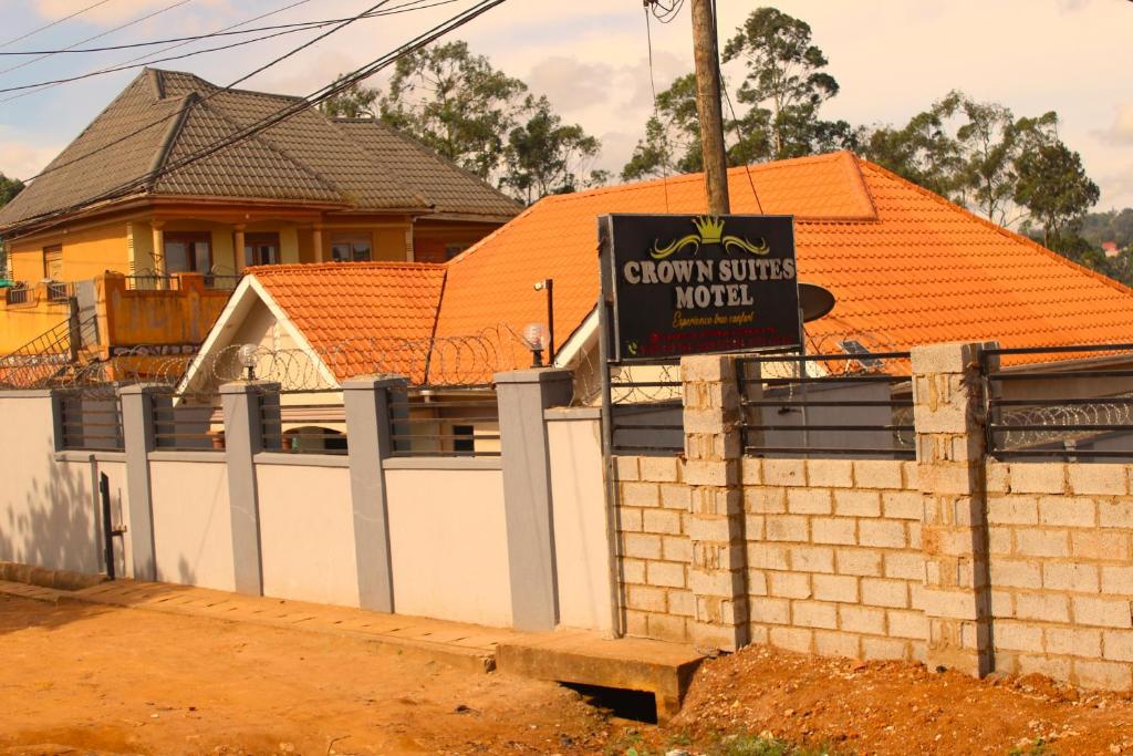 a sign on a fence in front of a house at Crown Suites Motel in Masaka