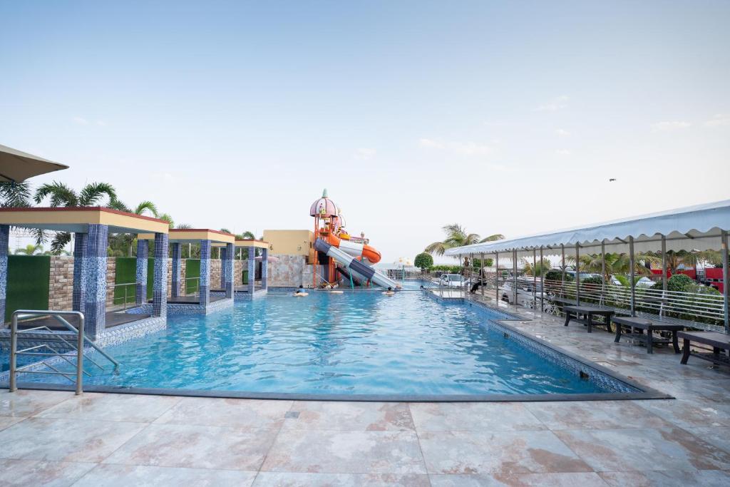 a person jumping into a swimming pool at a resort at Sher Bengal Beach Resort in Mandarmoni