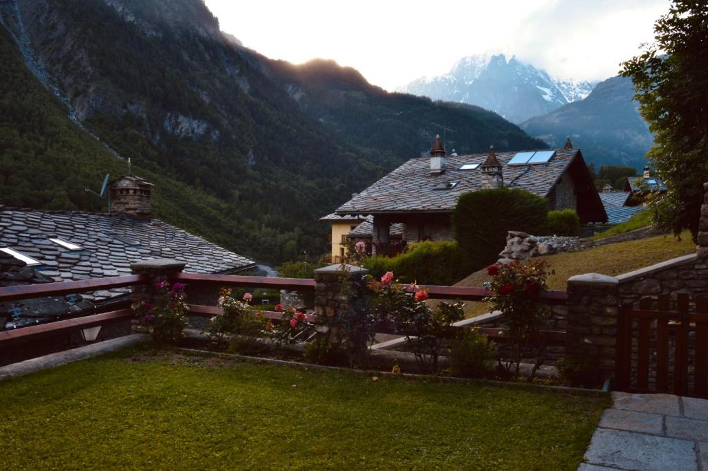 a house with a fence and mountains in the background at La Maison de Nocent in Pré-Saint-Didier